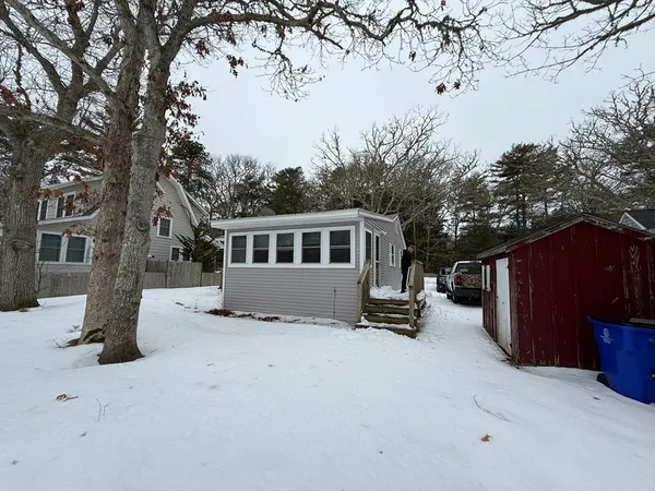 a view of a house with a yard covered in snow