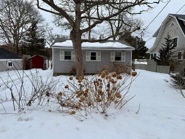 a front view of a house with a yard covered in snow