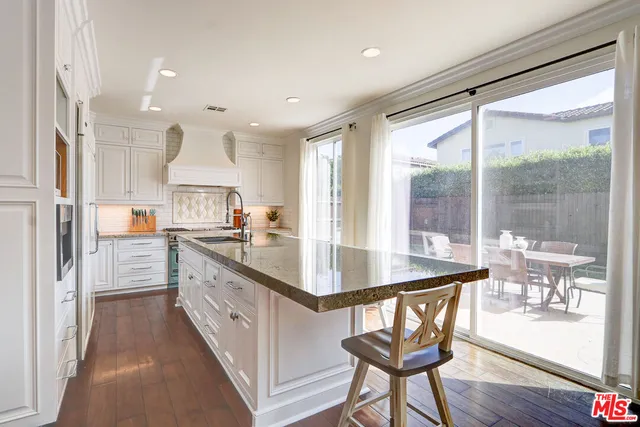 a kitchen with granite countertop white cabinets and stainless steel appliances