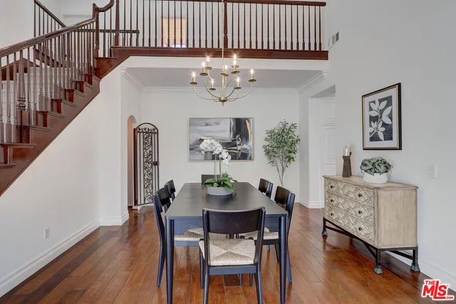 a view of a dining room with furniture a chandelier and wooden floor