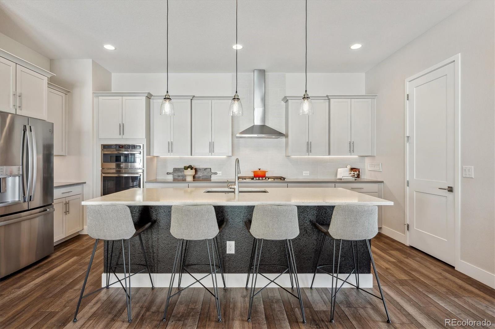 2095 Rim Ridge Drive Castle Pines, CO 80108 - Photo 11 of 46 a kitchen with a sink cabinets and wooden floor