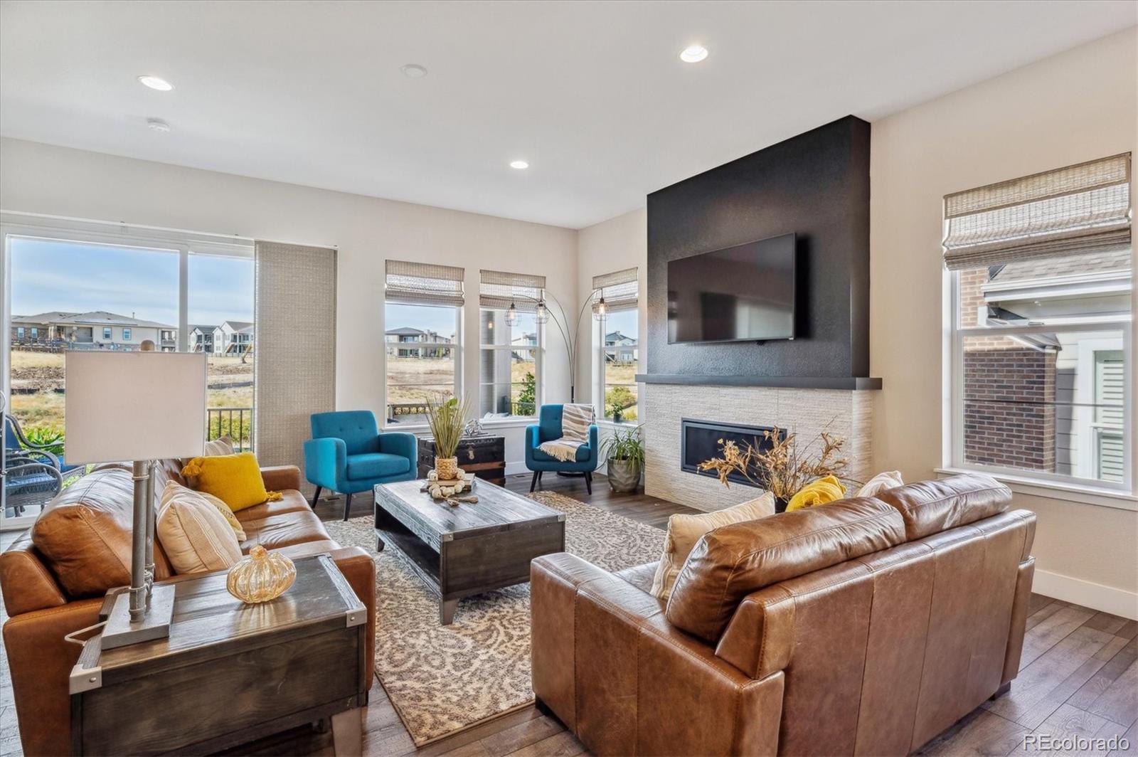 2095 Rim Ridge Drive Castle Pines, CO 80108 - Photo 16 of 46 a living room with fireplace furniture and a flat screen tv