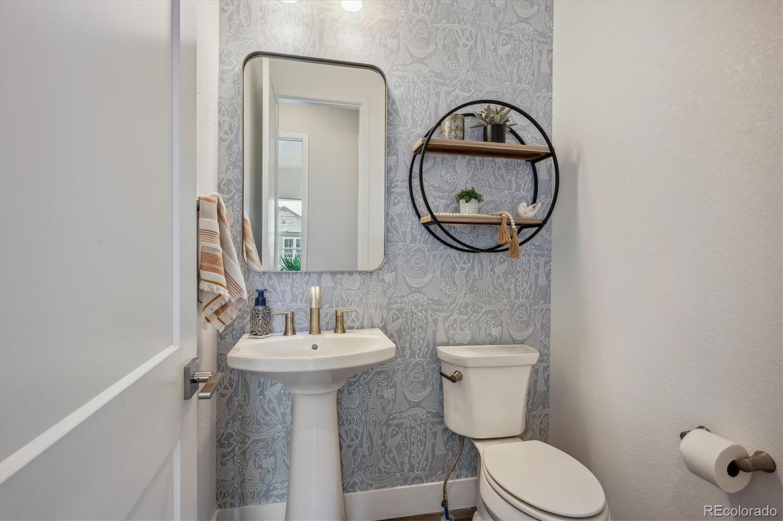 2095 Rim Ridge Drive Castle Pines, CO 80108 - Photo 25 of 46 a bathroom with a toilet a sink and a mirror