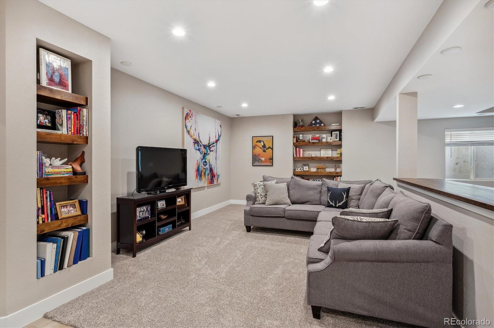 2095 Rim Ridge Drive Castle Pines, CO 80108 - Photo 30 of 46 a living room with furniture and a flat screen tv
