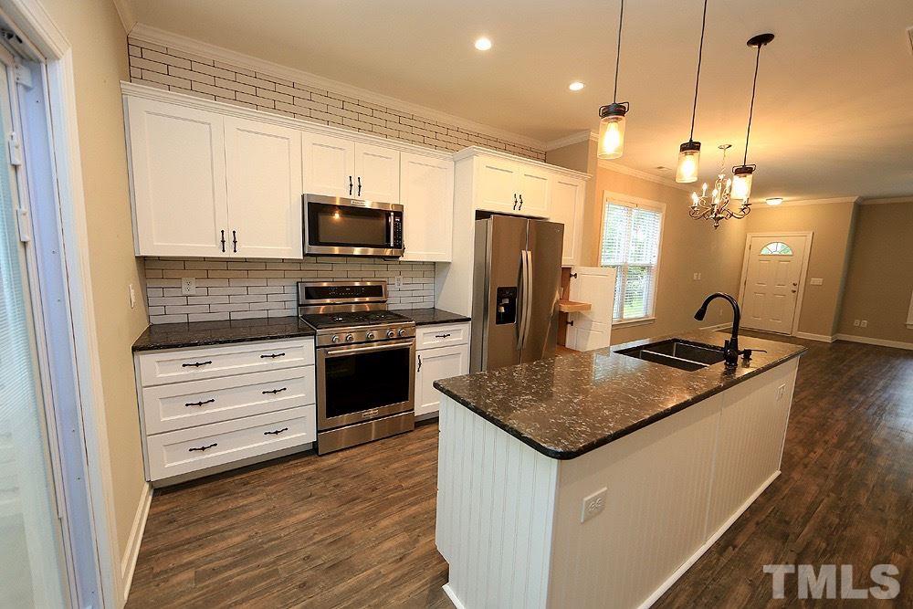 1009 Dual Parks Road Apex, NC 27502 - Photo 6 of 15 Pendant lighting and subway tile backsplash add even more features to this awesome kitchen.