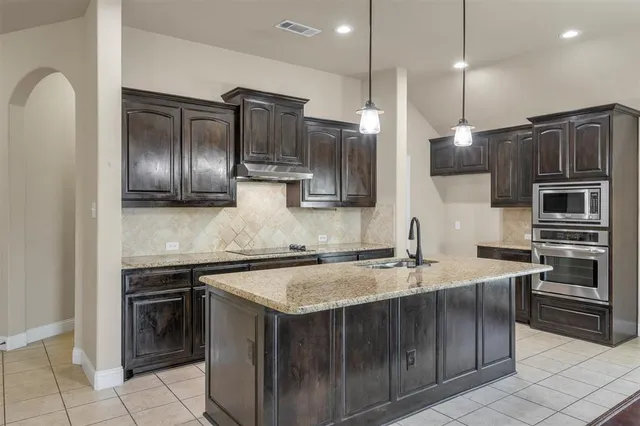 a kitchen with stainless steel appliances a sink stove and refrigerator