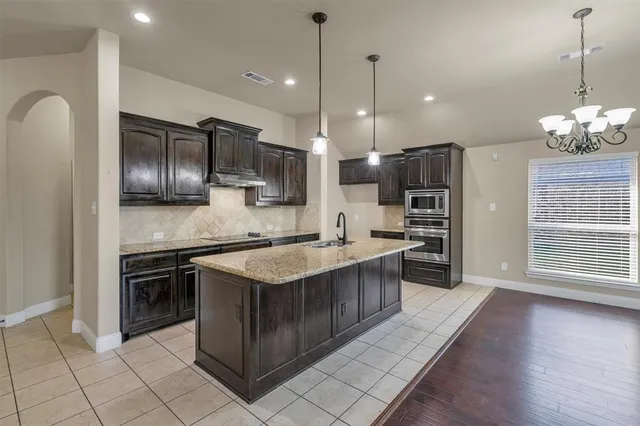 a kitchen with stainless steel appliances granite countertop a stove a sink and a refrigerator