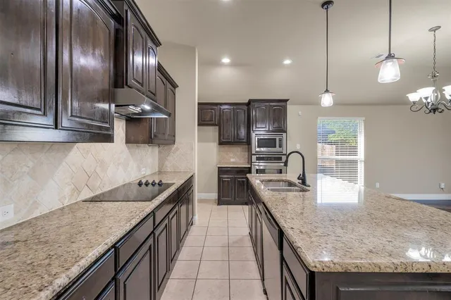 a kitchen with granite countertop stainless steel appliances and wooden cabinets