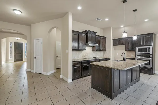 a kitchen with stainless steel appliances granite countertop a sink and a stove