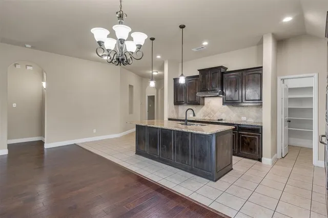 a kitchen with kitchen island granite countertop stainless steel appliances a stove refrigerator and cabinets