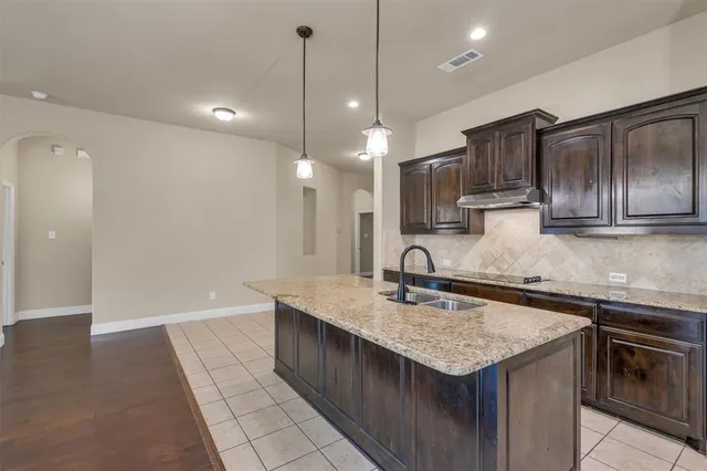 a kitchen with a sink a counter space appliances and cabinets