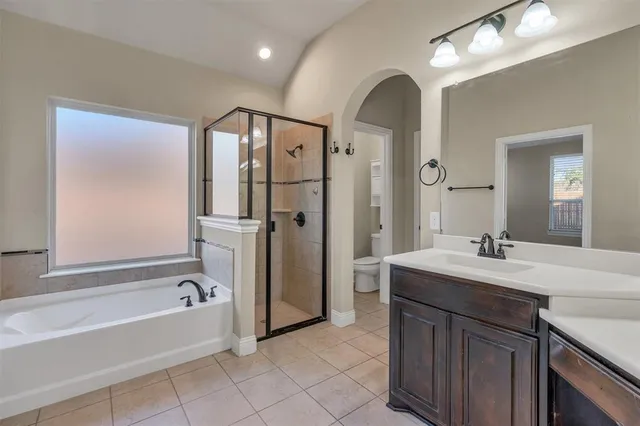 a spacious bathroom with a bathtub sink and mirror