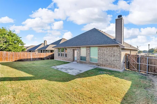 a view of a house with a yard and fence