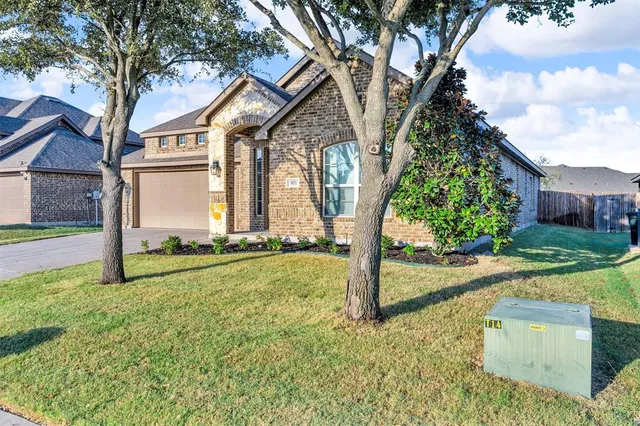 a view of a house with backyard and tree