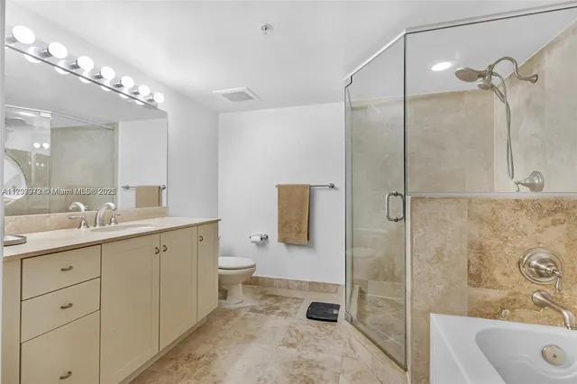 a bathroom with a double vanity sink toilet mirror and shower