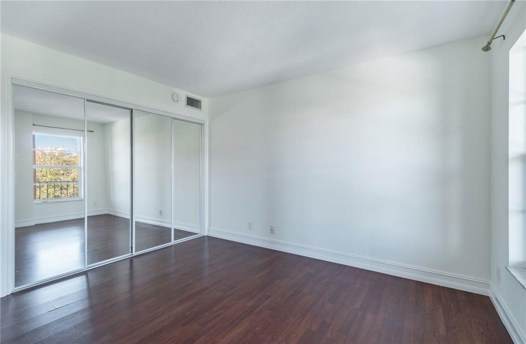950 Ponce De Leon Road, Unit 408 Boca Raton, FL 33432 - Photo 15 of 51 an empty room with wooden floor and windows