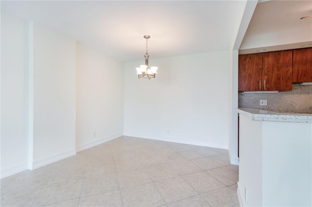 950 Ponce De Leon Road, Unit 408 Boca Raton, FL 33432 - Photo 7 of 51 an empty room with chandelier fan