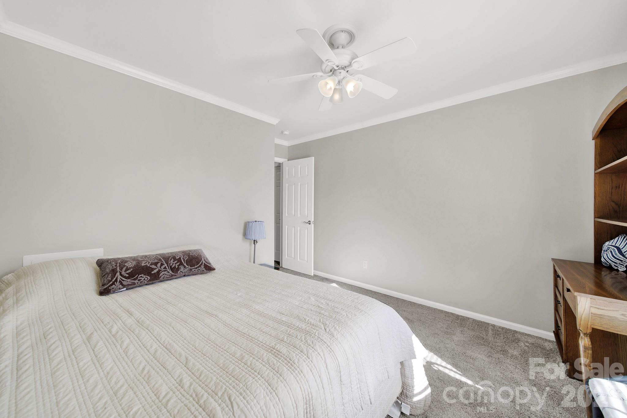 263 Fox Hollow Road Mooresville, NC 28117 - Photo 26 of 44 a bedroom with a bed and a chandelier