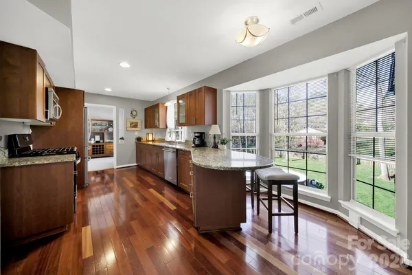 a kitchen with stainless steel appliances granite countertop sink stove top oven and cabinets