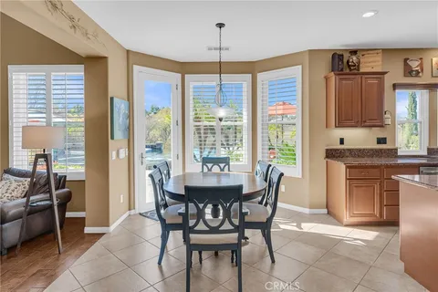 a dining room with furniture a chandelier and wooden floor