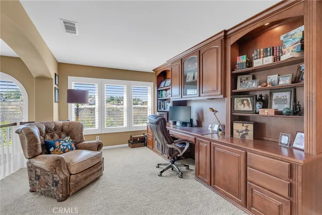 a view of a workspace with furniture and a window