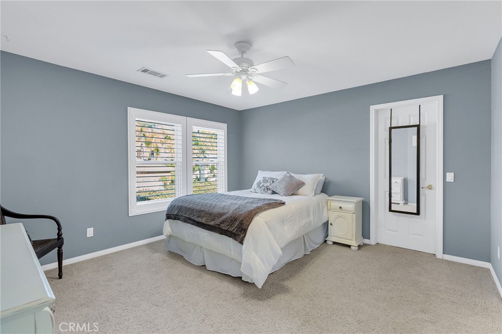 14143 Ashton Lane Riverside, CA 92508 - Photo 29 of 40 a spacious bedroom with a bed a chandelier and a window