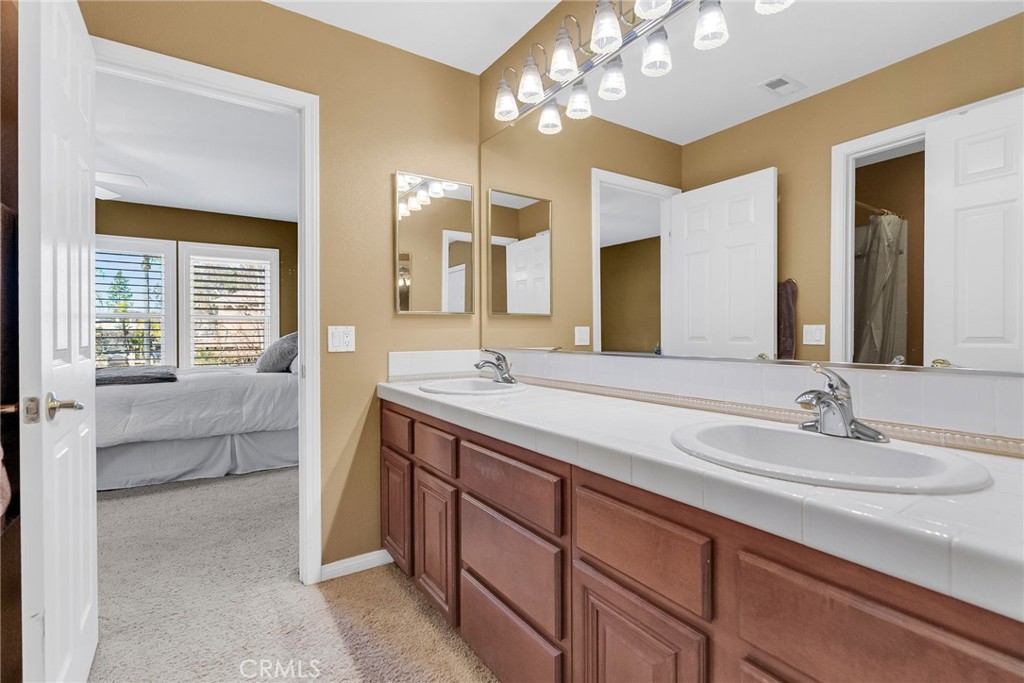 14143 Ashton Lane Riverside, CA 92508 - Photo 30 of 40 a bathroom with a double vanity sink and a mirror