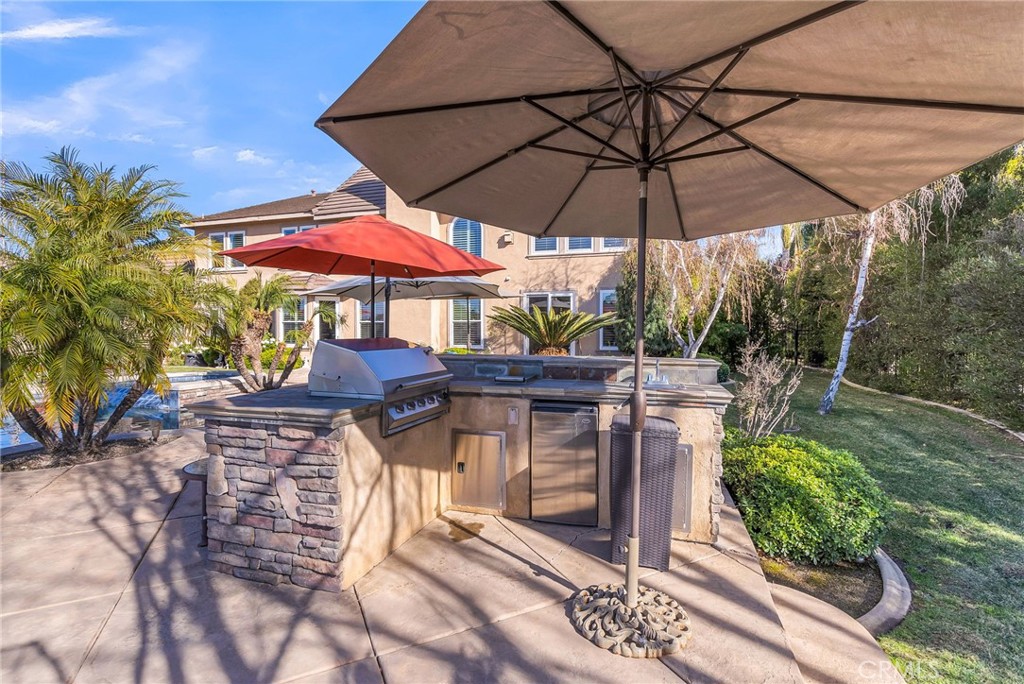 14143 Ashton Lane Riverside, CA 92508 - Photo 36 of 40 a patio with a patio table and chairs under an umbrella