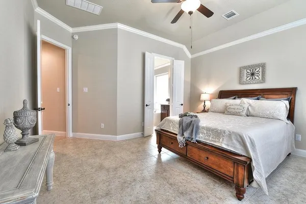 a spacious bedroom with a bed and a chandelier
