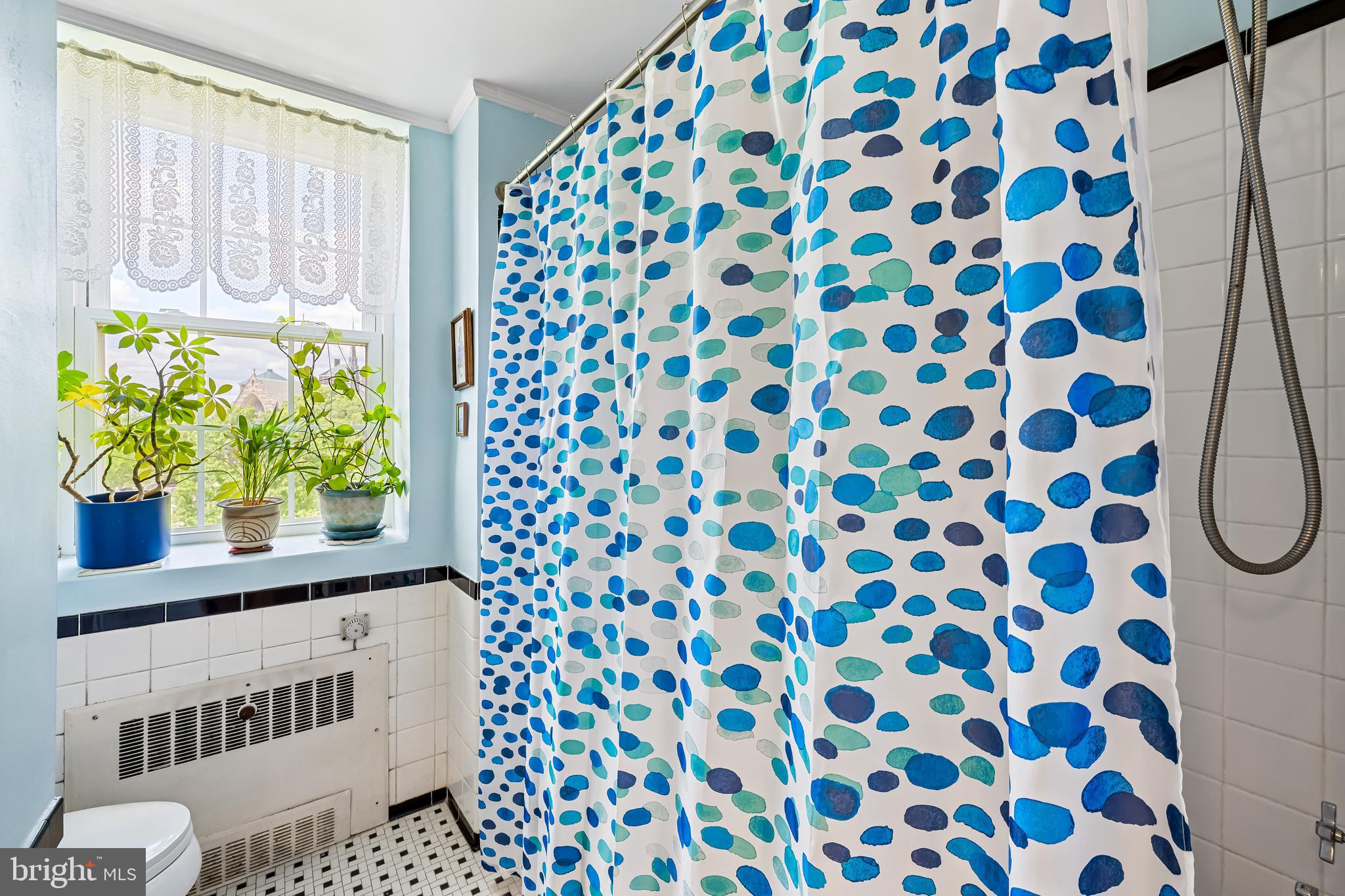 3601 Greenway, Unit 705 Baltimore, MD 21218 - Photo 15 of 30 a bathroom with a shower curtain and a window