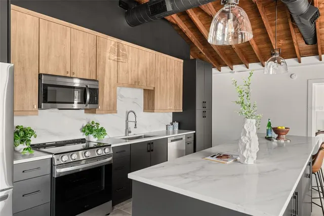 a kitchen with stainless steel appliances granite countertop a sink a stove and a refrigerator