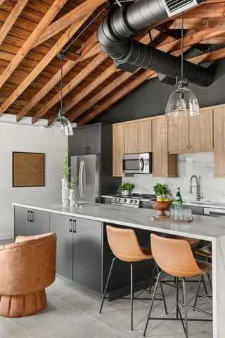 a kitchen with stainless steel appliances granite countertop a sink a stove and a wooden cabinets