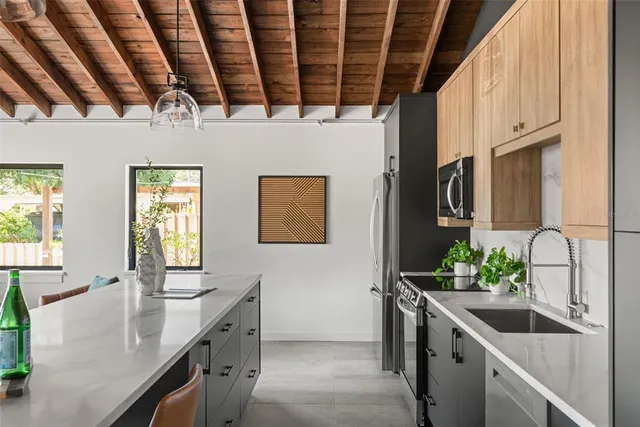 a kitchen with stainless steel appliances granite countertop a sink a stove and a refrigerator