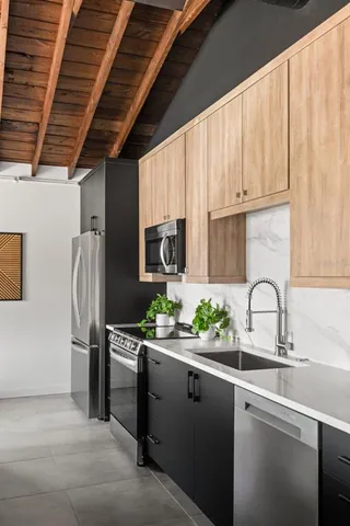 a kitchen with stainless steel appliances a sink a counter space and a refrigerator