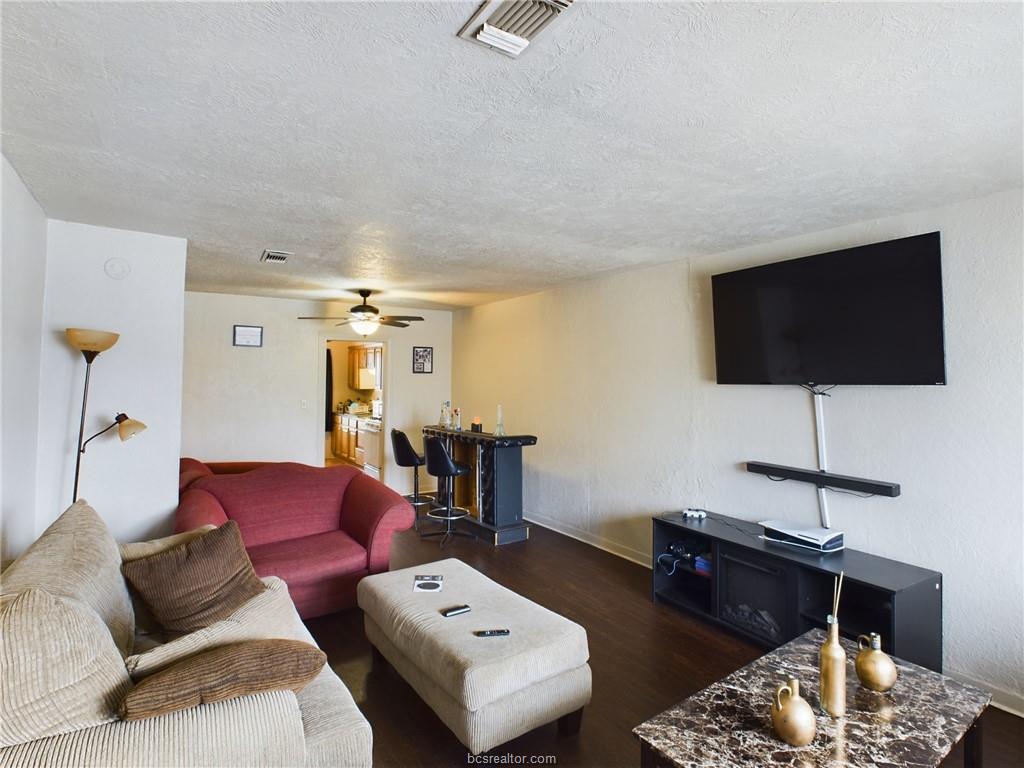 1316 Antone Street, Unit B Bryan, TX 77803 - Photo 2 of 7 Living room with a textured ceiling, dark wood-type flooring, and a ceiling fan
