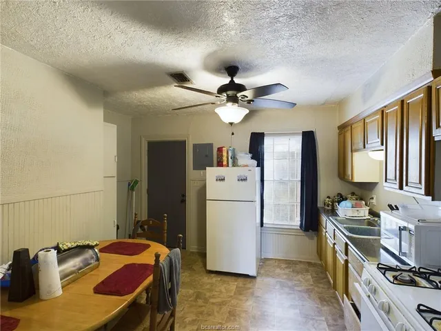 a kitchen with a refrigerator and a stove top oven