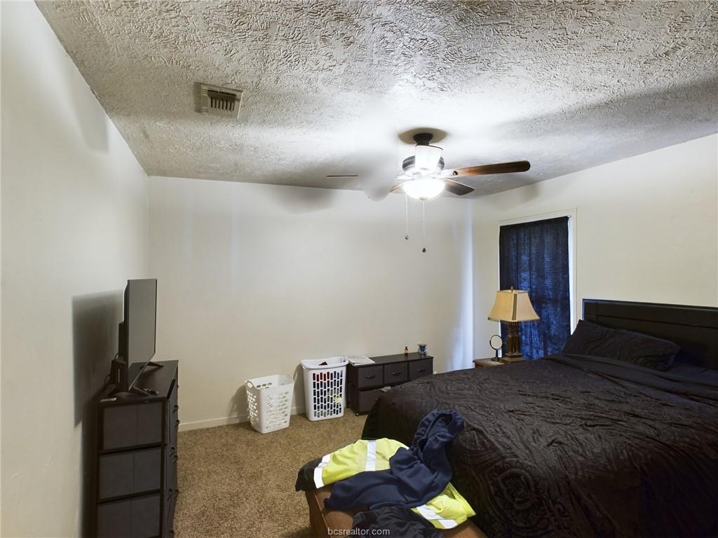 1316 Antone Street, Unit B Bryan, TX 77803 - Photo 4 of 7 Carpeted bedroom featuring a textured ceiling and a ceiling fan