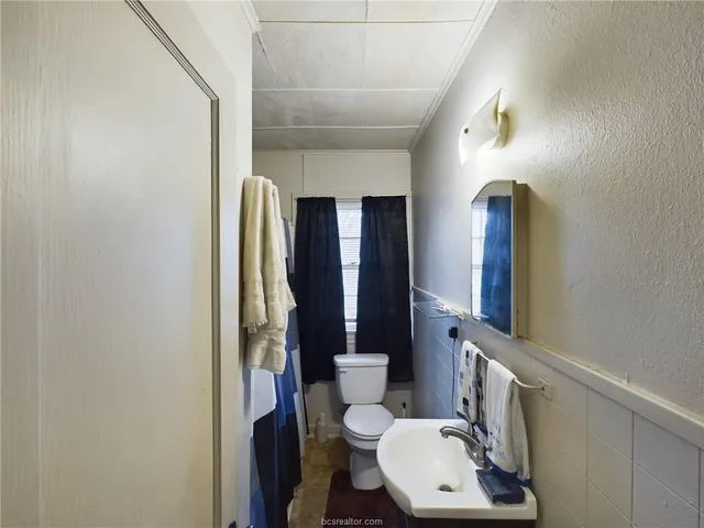 a bathroom with a toilet sink and mirror