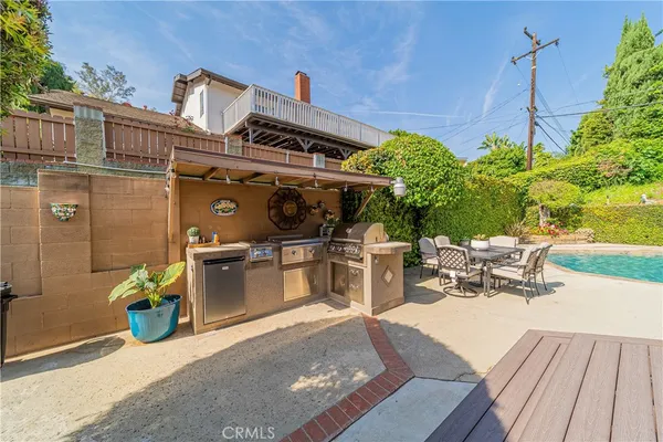 a view of a patio with table and chairs with wooden floor and potted plants
