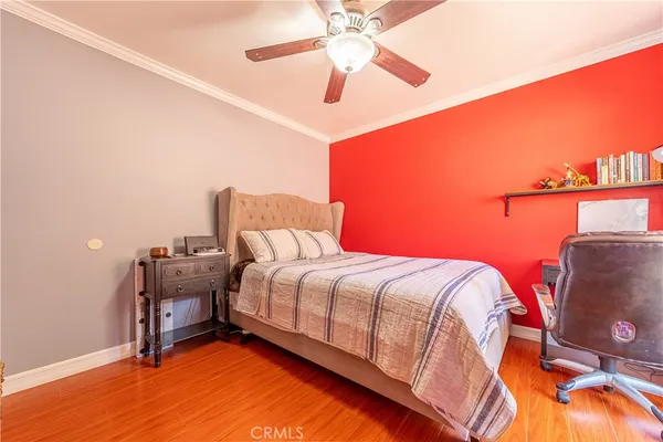 a bedroom with a bed and a chandelier fan