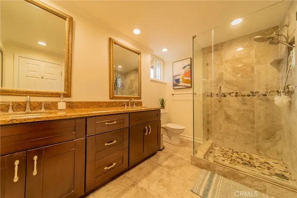 a bathroom with a granite countertop sink mirror and shower