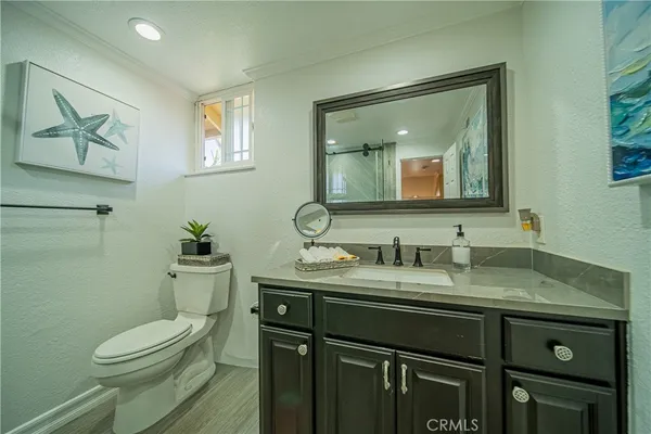 a bathroom with a granite countertop toilet sink and mirror
