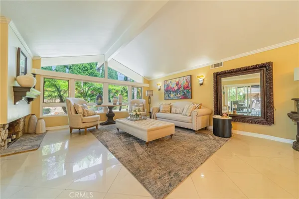 a living room with furniture large windows and wooden floor