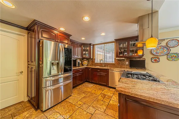 a kitchen with stainless steel appliances granite countertop a refrigerator and a stove