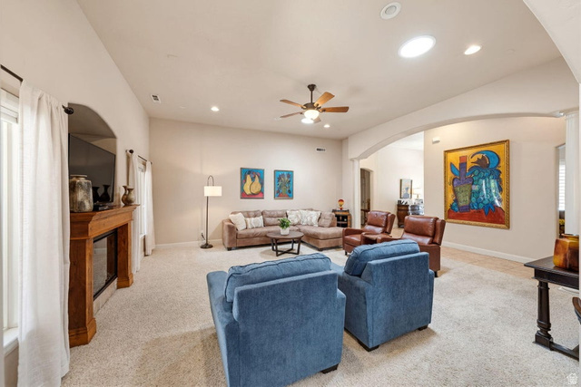 1609 East 10 S Street St. George, UT 84790 - Photo 16 of 68 Spacious living area featuring vaulted ceilings, a ceiling fan, arched doorways, a wood-finish fireplace, and recessed lighting with a skylight
