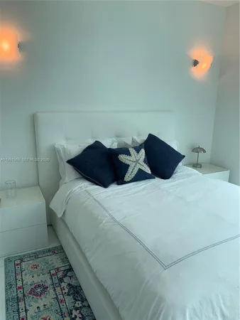 a large bed in a bedroom next to a lamp