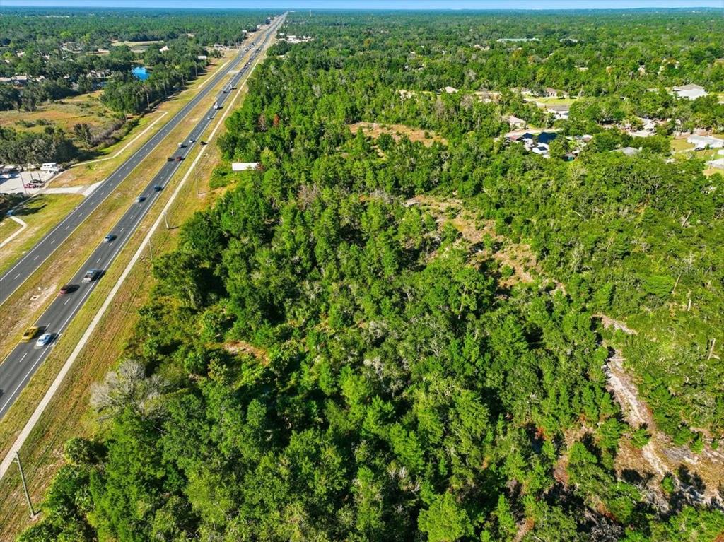 7124 Commercial Way Weeki Wachee, FL 34613 - Photo 25 of 30 a view of a green field with lots of bushes