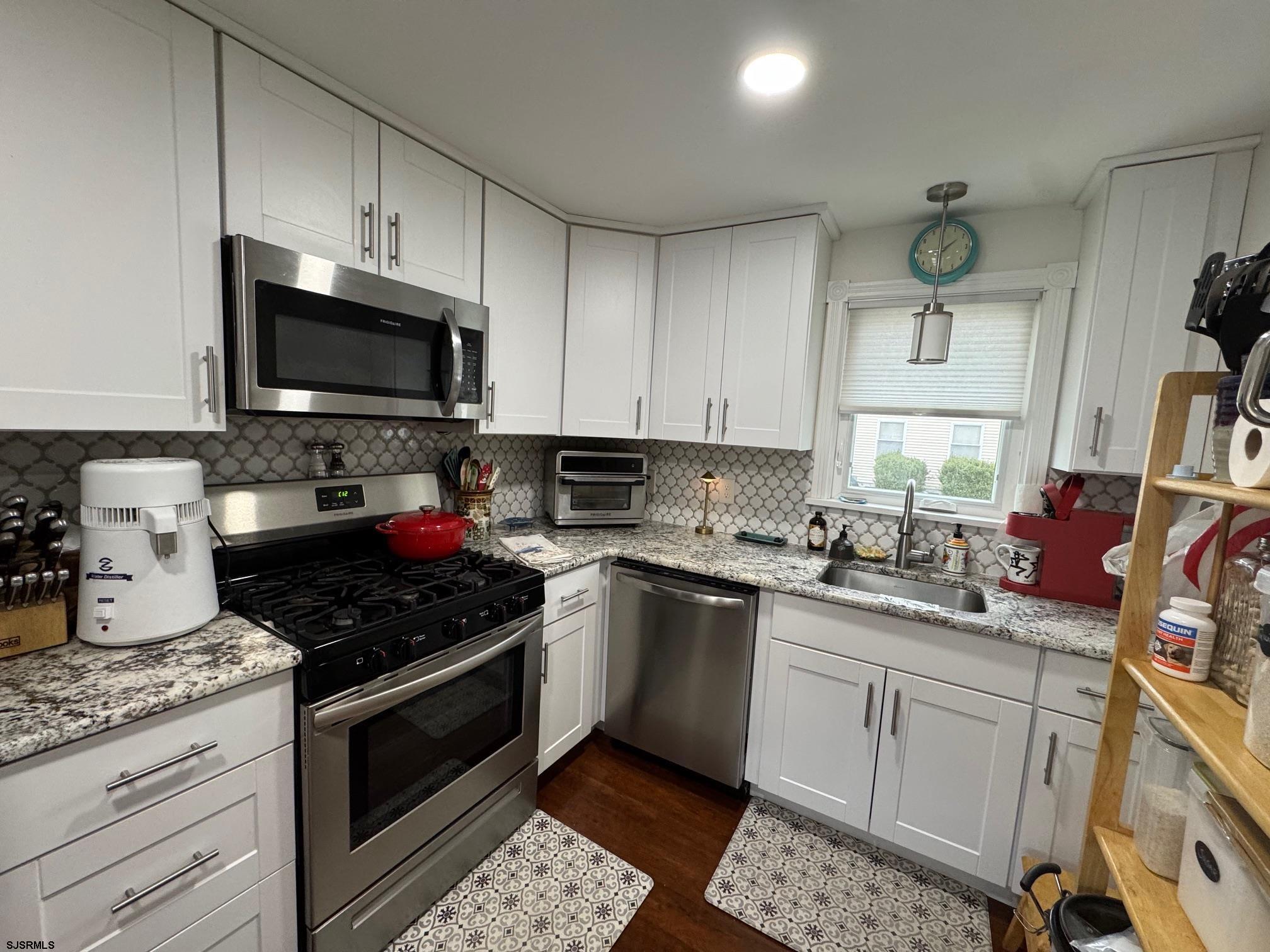 1801 Tilton Road Northfield, NJ 08225 - Photo 4 of 30 a kitchen with granite countertop a sink a stove top oven and cabinetry