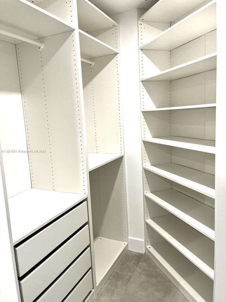 3530 Mystic Pointe Drive, Unit PH08 Aventura, FL 33180 - Photo 8 of 11 a view of walk in closet with empty racks