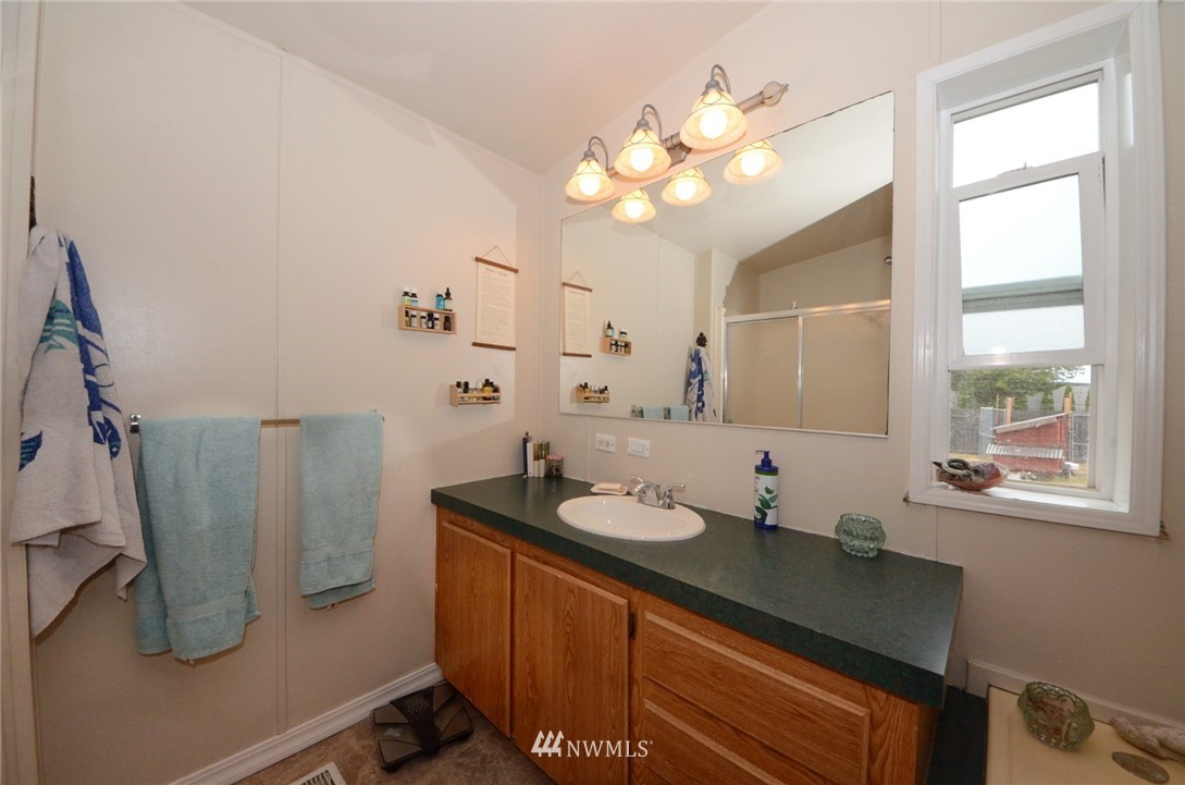 18224 Pendleton Street Southwest Rochester, WA 98579 - Photo 14 of 35 a bathroom with a sink a mirror and a shower